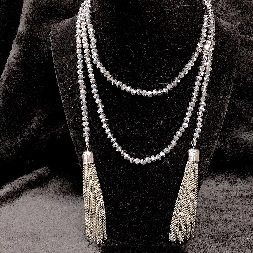 Woman’s grey and clear faceted bead necklace with silver tone tassels